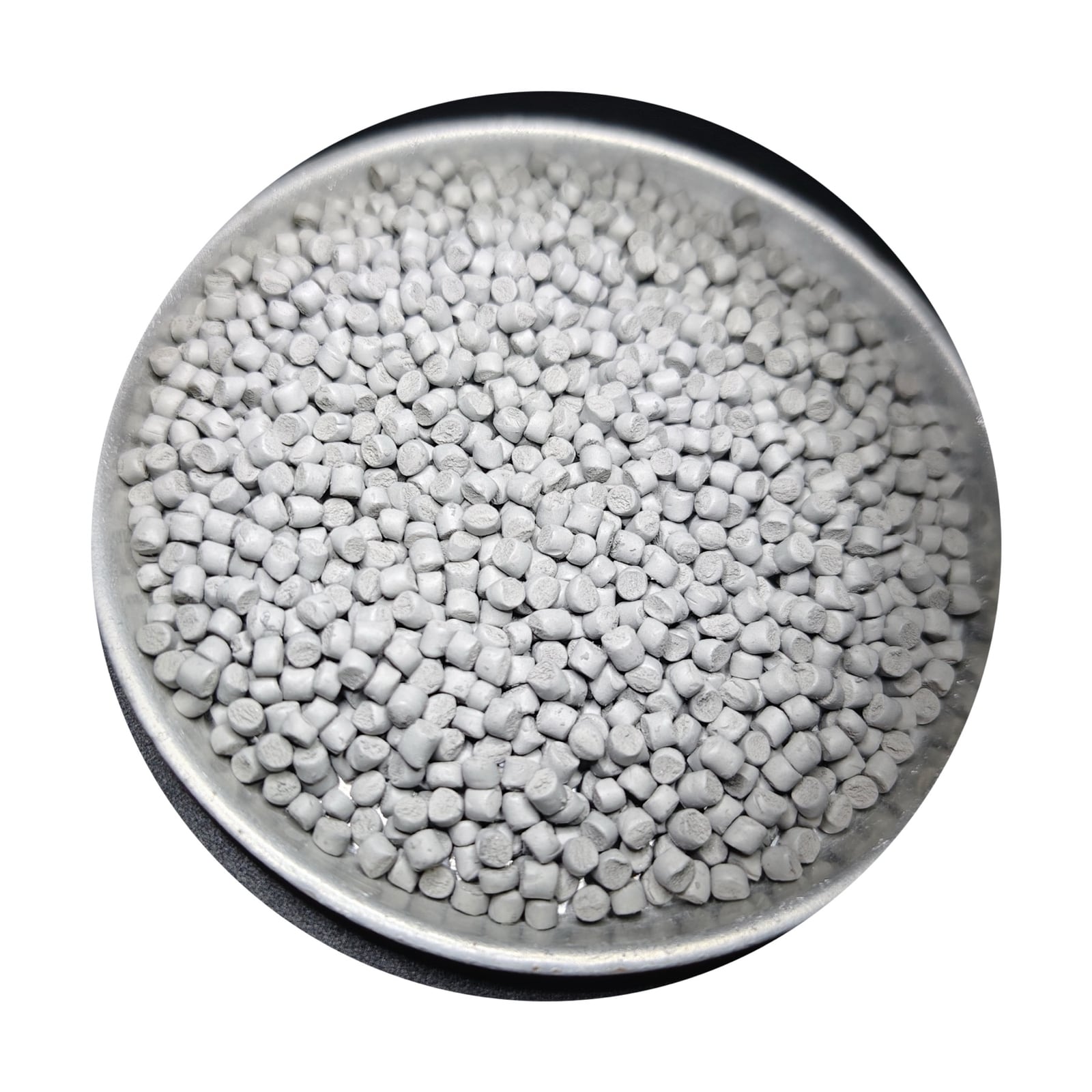 Gray MIM feedstock granules in a round metal dish